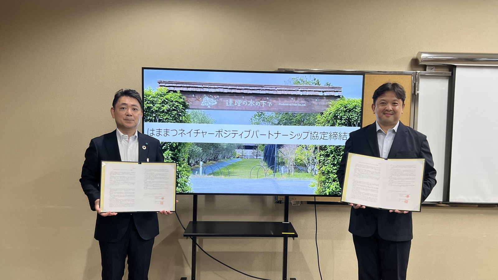 はままつネイチャーポジティブパートナーシップ協定締結式で協定書を掲げる出席者